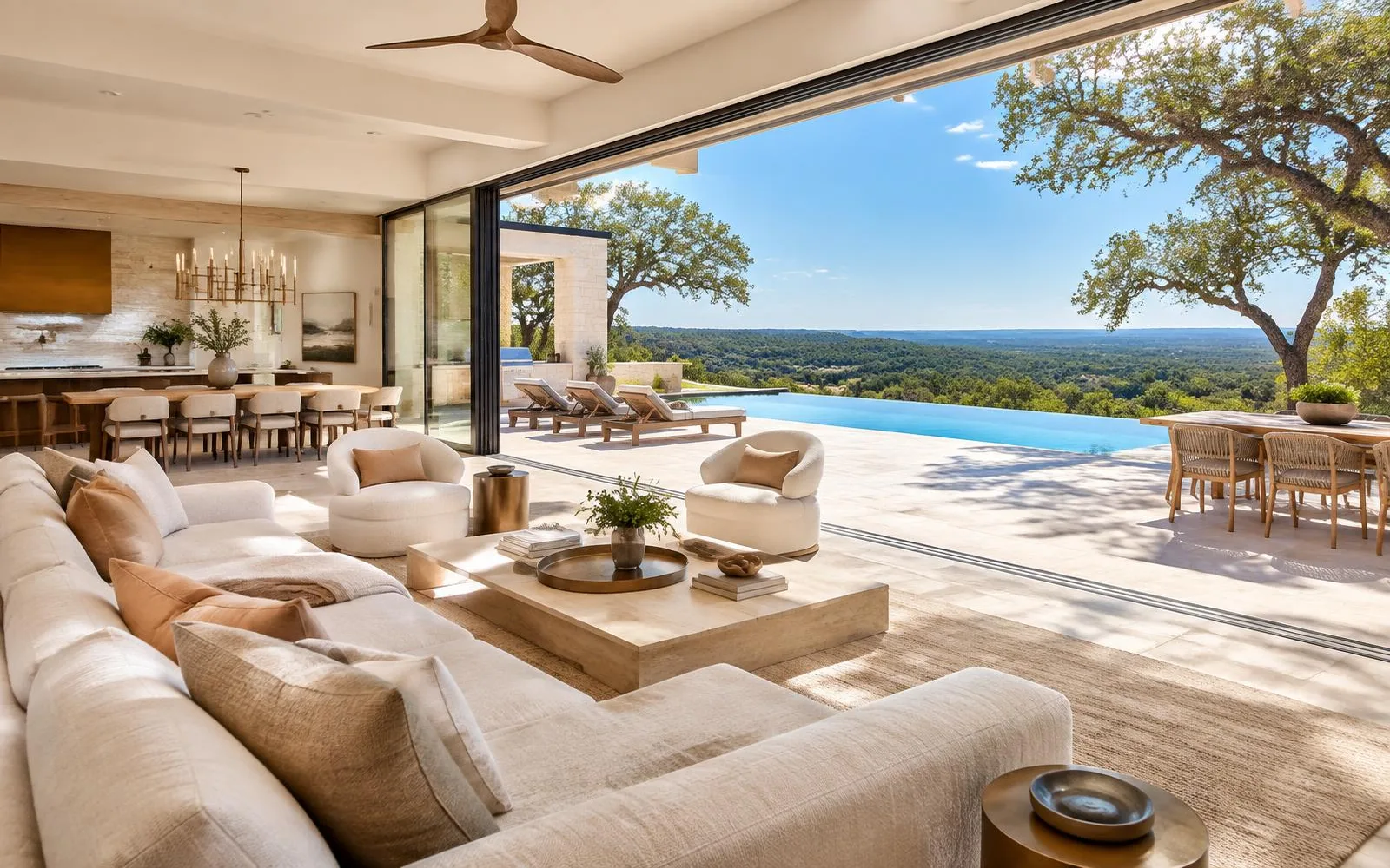 Luxury Texas hill country living room opening through slim black aluminum Fleetwood sliding glass walls onto a sunlit terrace and infinity pool